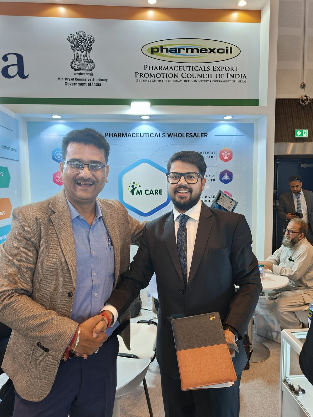 M Care Arab Health 2024 booth — meeting table with buyer documentation.