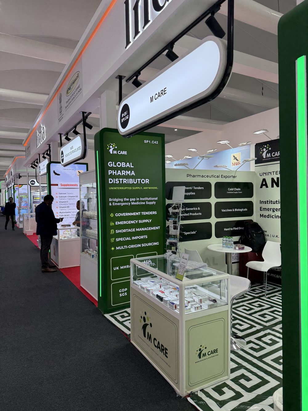 Buyer meeting at M Care WHX 2026 booth, team members on stand discussing product range.